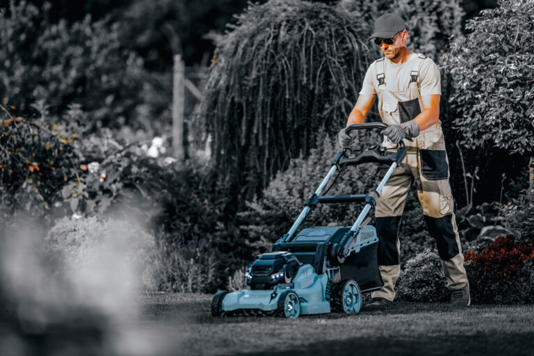 Garden Maintenance Professional Services. Caucasian Gardener Taking Care of the Grass Using Riding Lawn Mower During Summer Season.